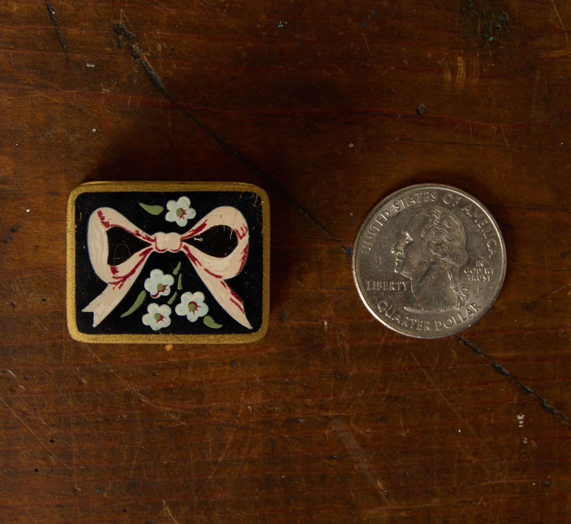 1940S ENAMELED BRASS PETITE PILL BOX WITH HAND PAINTED BOW