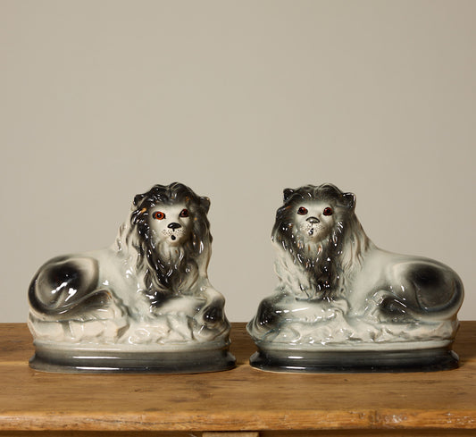 PAIR OF BLACK STAFFORDSHIRE LIONS