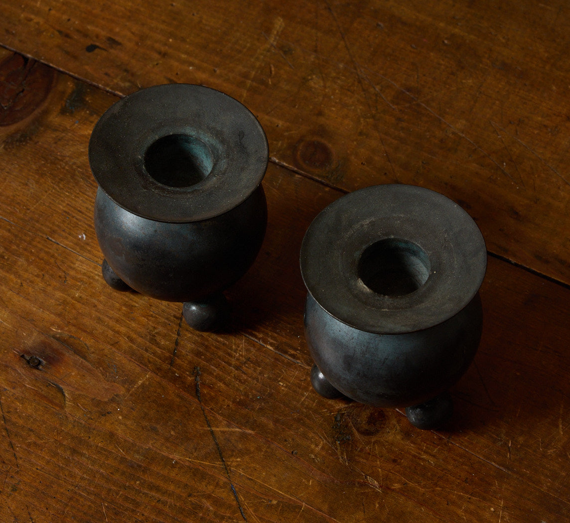 PAIR OF VINTAGE PATINATED FOOTED ORB CANDLESTICK HOLDERS